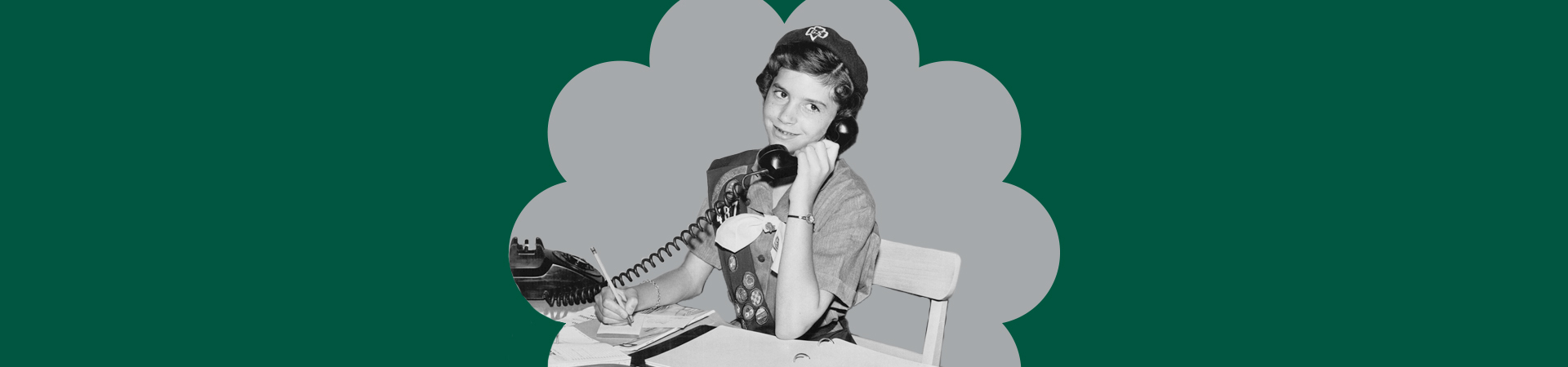  black and white historical photo of a girl scout talking on a rotary phone 